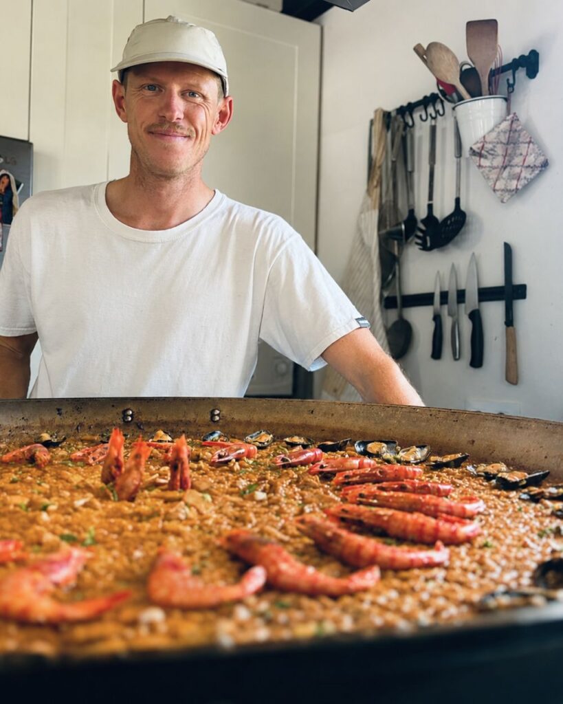 Eduard Nicolau, fundador de SA|ROZ, preparando una paella en Mallorca.